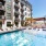 Savannah GA Apartments for Rent - Olmsted Savannah - Resort-Style Pool Area with Lounge Chairs, Daybeds, and Palm Trees