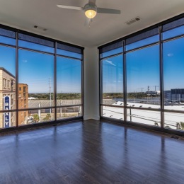 a large room with wood style flooring and floor-ceiling windows
