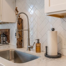 close up of a kitchen counter with a sink and paper towel holder